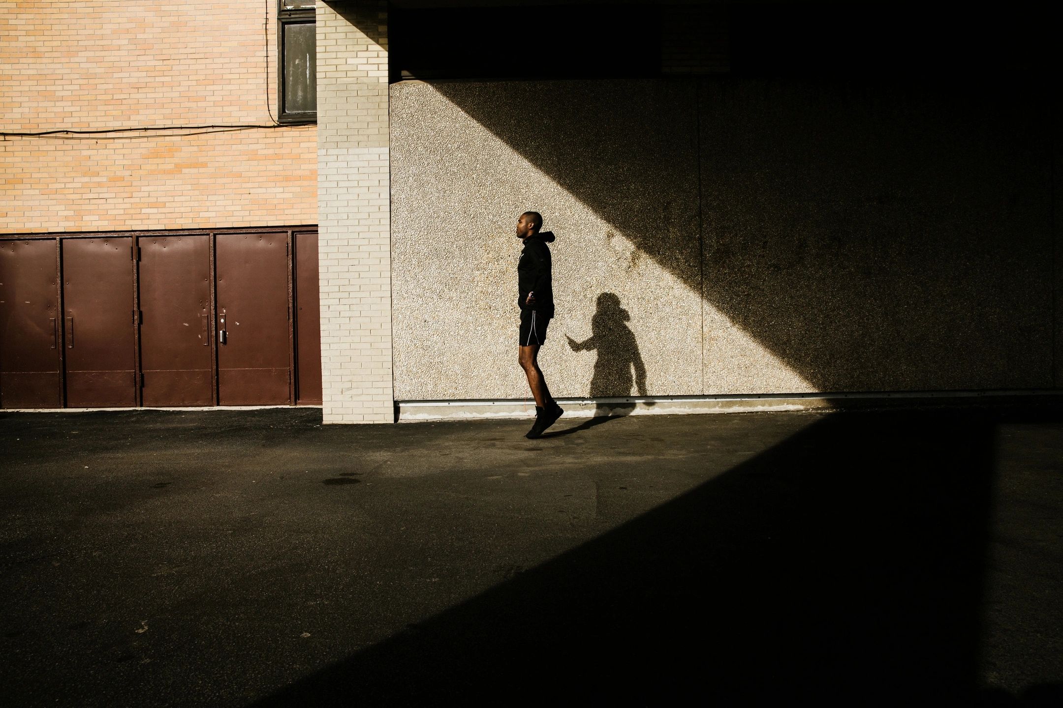 Corredor en callejón urbano con sombras dramáticas